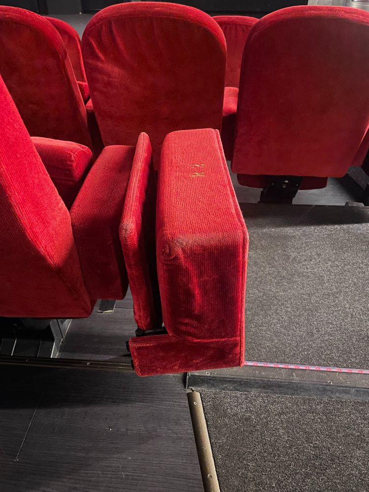 Roter Klappsitz am Rand einer Sitzreihe im Monopol Kino