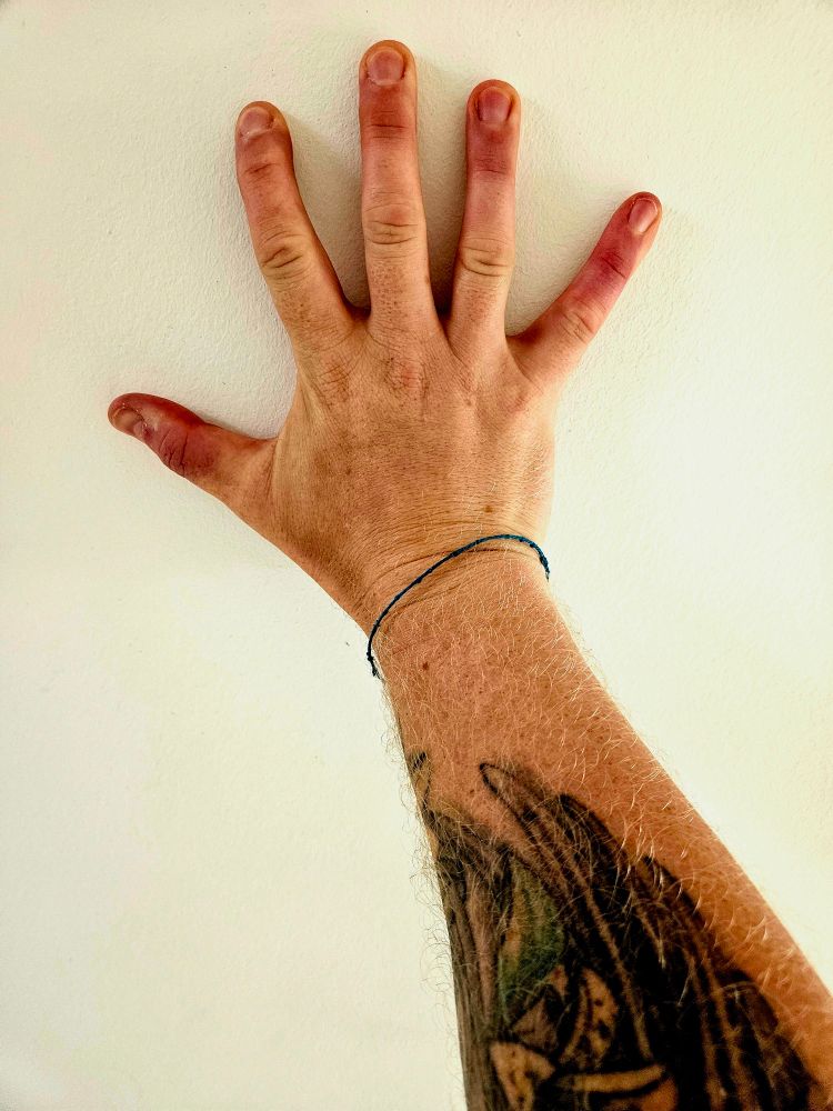 Meine Hand und Unterarm mit Kraft an die Wand gedrückt