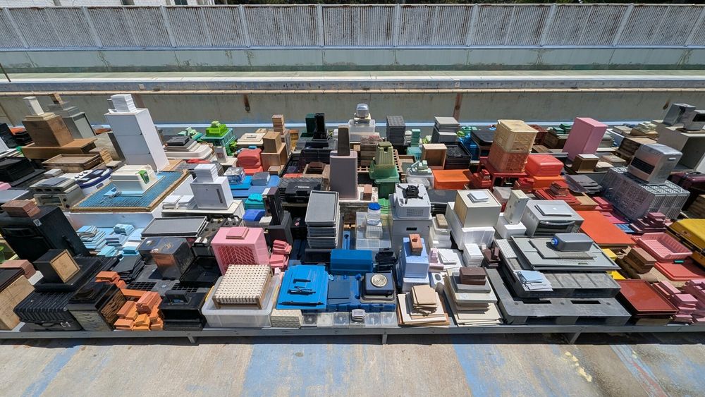 It looks like a city from the sky, but it's actually hundreds of square and rectangular objects (boxes, books, cubes, etc) all perfectly stacked and arranged by color. Oh, and this installation is inside an old abandoned swimming pool.