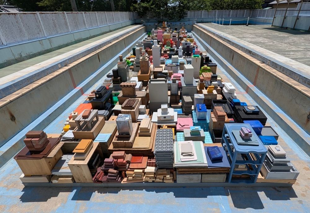 It looks like a city from the sky, but it's actually hundreds of square and rectangular objects (boxes, books, cubes, etc) all perfectly stacked and arranged by color. Oh, and this installation is inside an old abandoned swimming pool.