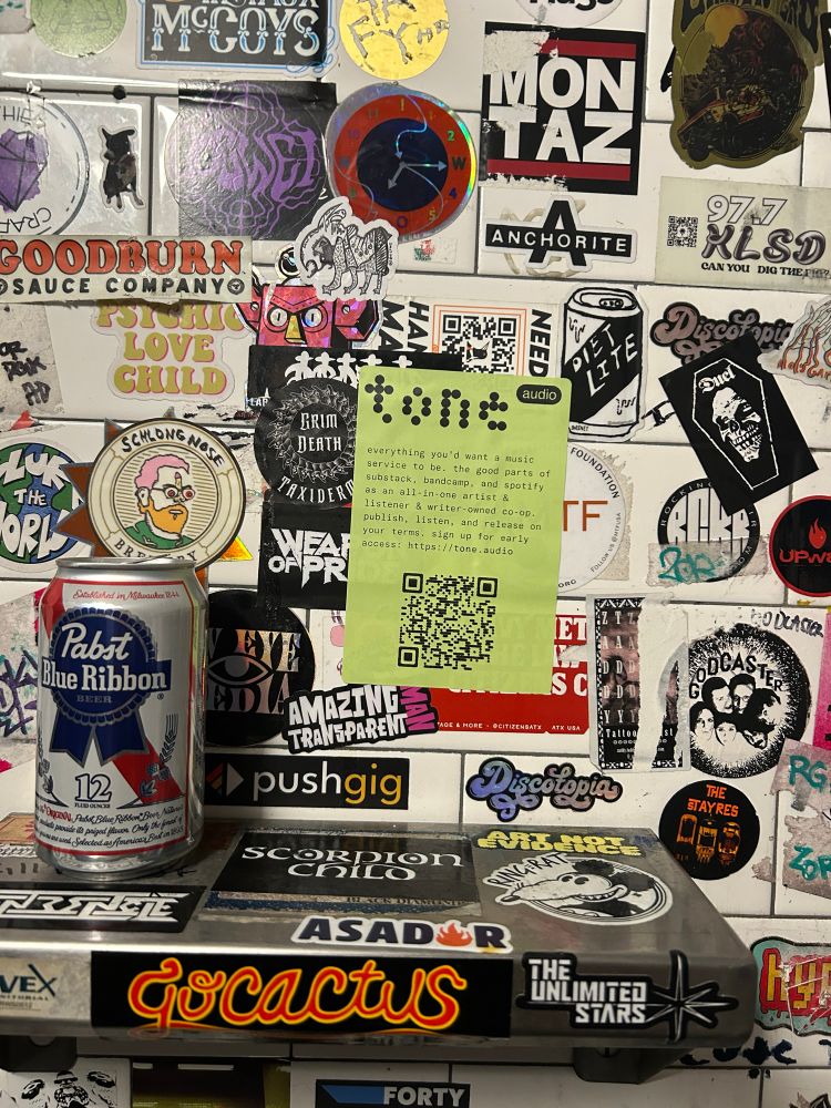 tone.audio promotional sticker, placed on a wall