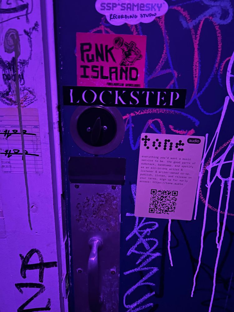tone.audio promotional sticker, placed on a wall