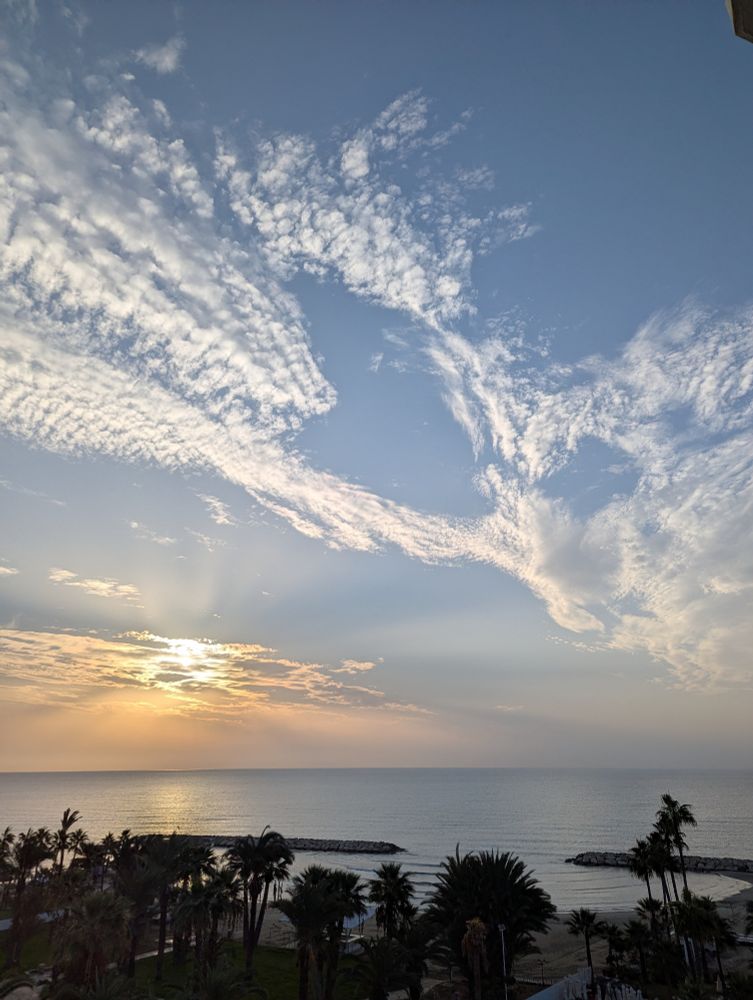 Aufgehende Sonne, blauer Himmel weiße Wolken.