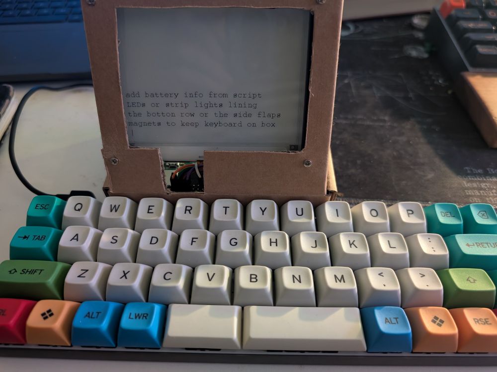 E-ink screen mounted in a box attached to a keyboard. Functions as a note taker 
