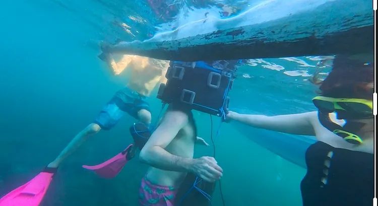 Someone inside the diving bell, the photo is taken underwater. 