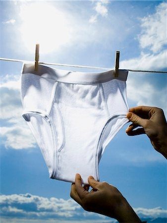 A pair of white briefs on the clothesline with the sun shining behind them