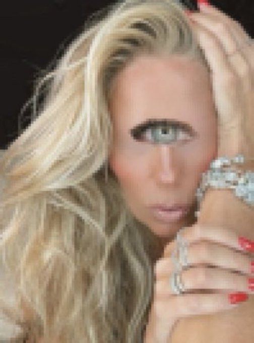 adriane galisteu (mulher loira, branca) ciclope, com um gigantesco olho azul no meio da cara.