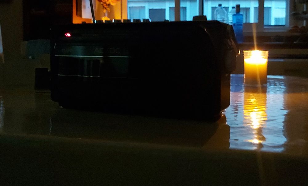 La misma radio del post anterior, a oscuras, con una vela al lado. Se ven las ventanas del edificio contrario algo iluminadas pero es cosa de la cámara de mi móvil y echar la foto en la hora azul.