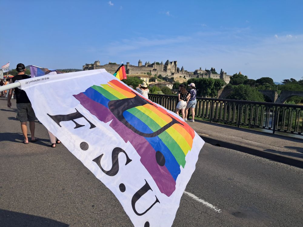 Drapeau FSU arc-en-ciel devant la Cité de Carcassonne.