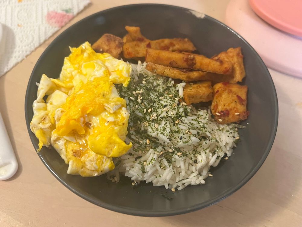 A picture of white rice with furikake, scrambled egg and seasoned tofu