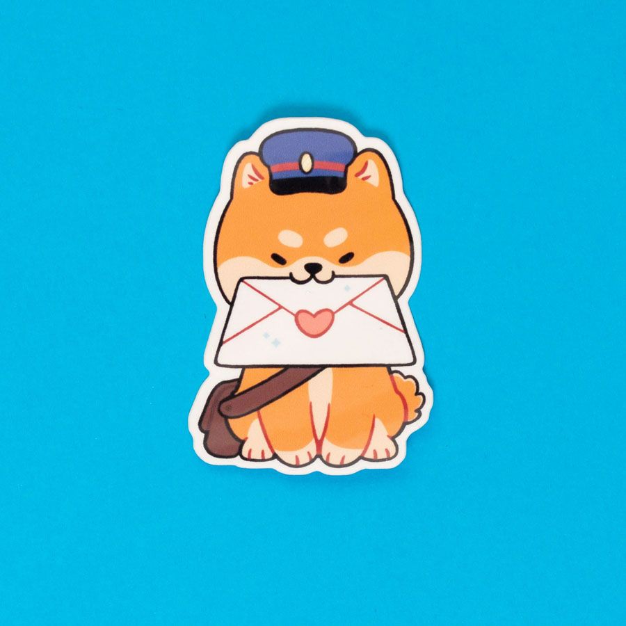 A single die-cut vinyl sticker depicting a Shiba Inu dressed in a postman cap and bag, holding an envelope in their mouth. The envelope is sealed with a heart.