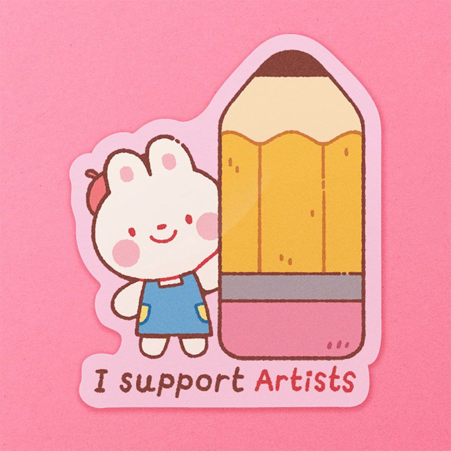A die-cut sticker depicting a bunny in an apron and a beret holding up a giant, stumpy pencil.