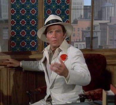 William Shatner wearing a Panama hat and a white suit, looking surprised 