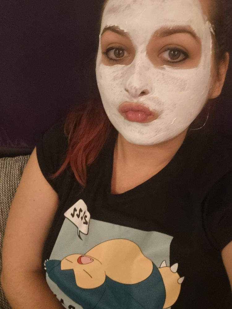 Selfie mit aufgetragener weisser Gesichtsmaske. Mund zum Kuss geformt. Auf dem T-Shirt das Motiv eines auf dem Rücken liegenden, schlafenden Relaxos und einer "Zzzz" Sprechblase.