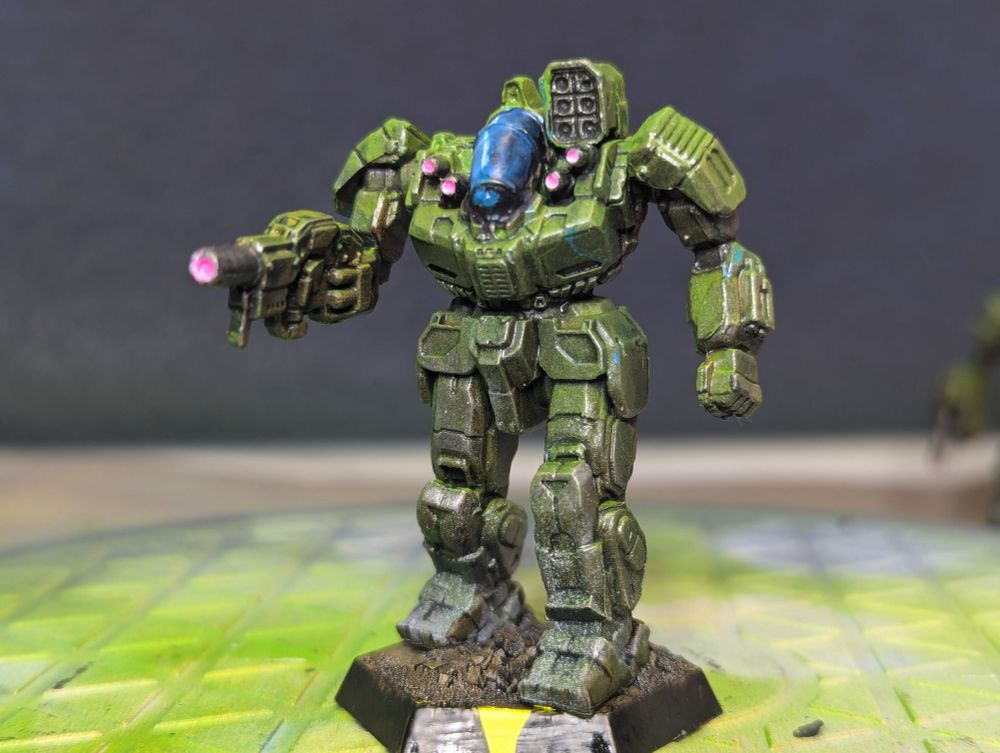 An olive drab green battle master with a blue cockpit 