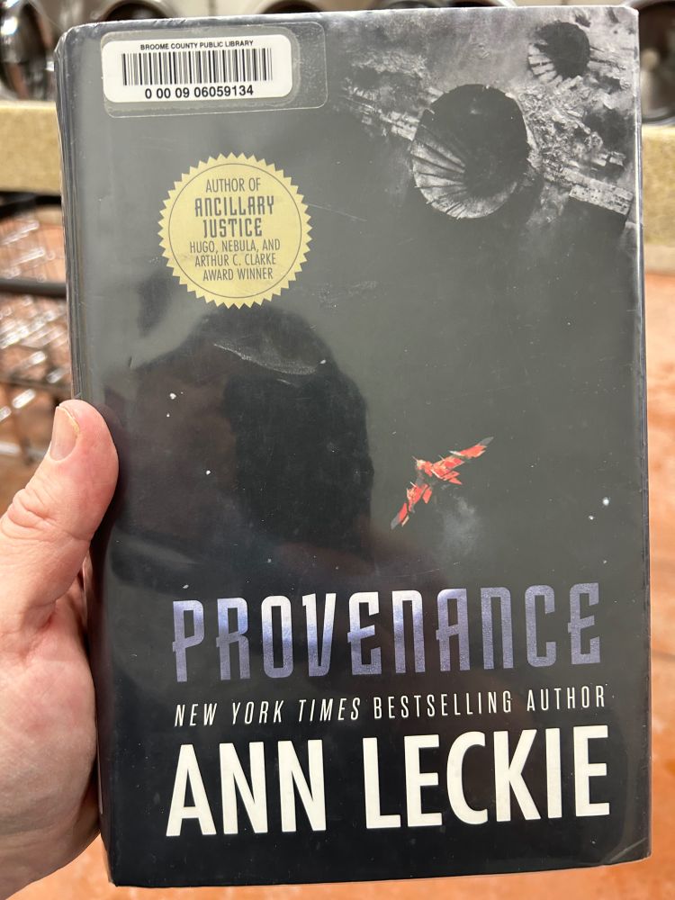 Me holding a copy of the above-mentioned book at the laundromat.