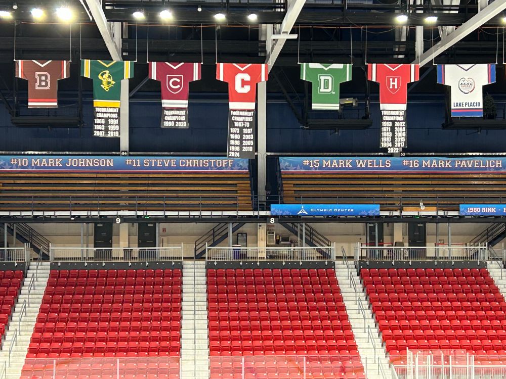 College hockey jerseys hanging from the rafters at the hockey rink at Lake Placid.
