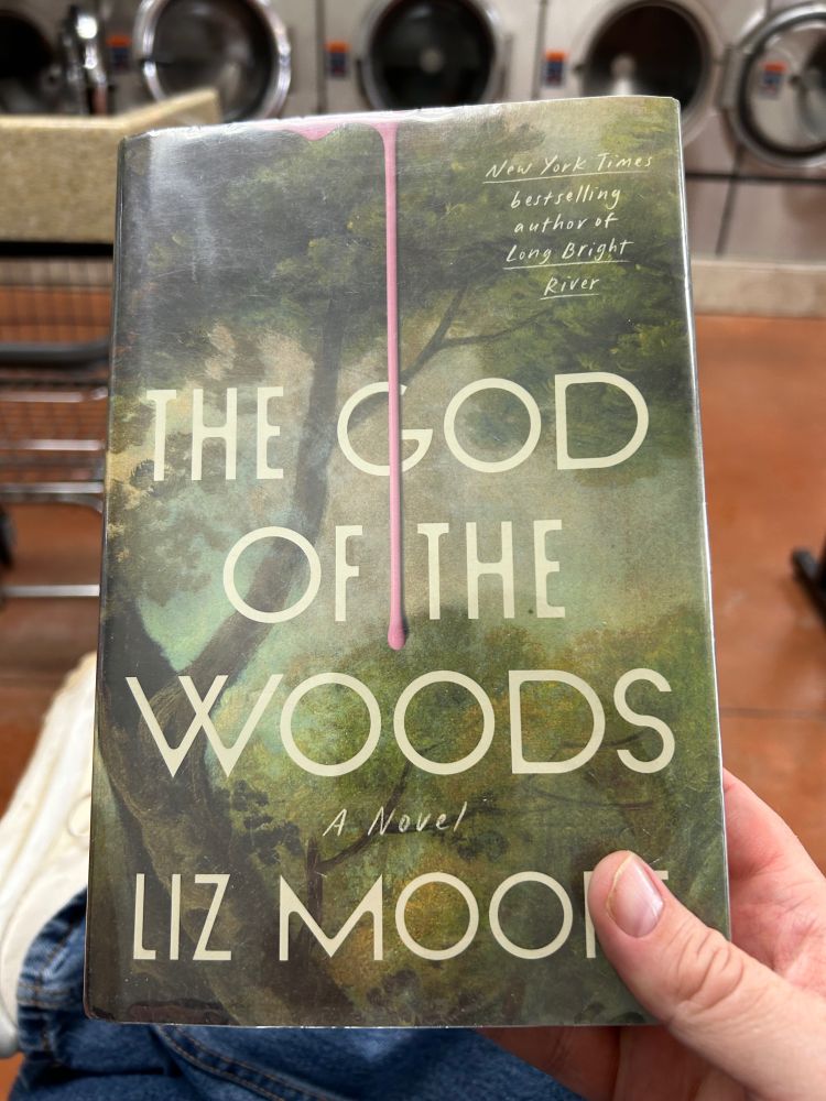 Me holding the above-mentioned book at the laundromat.