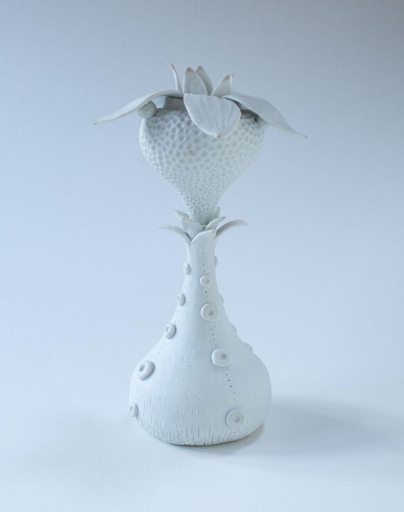 A porcelain sculpture of an imaginary play species, with a bulbous base and flower, and a number of petals at the top.