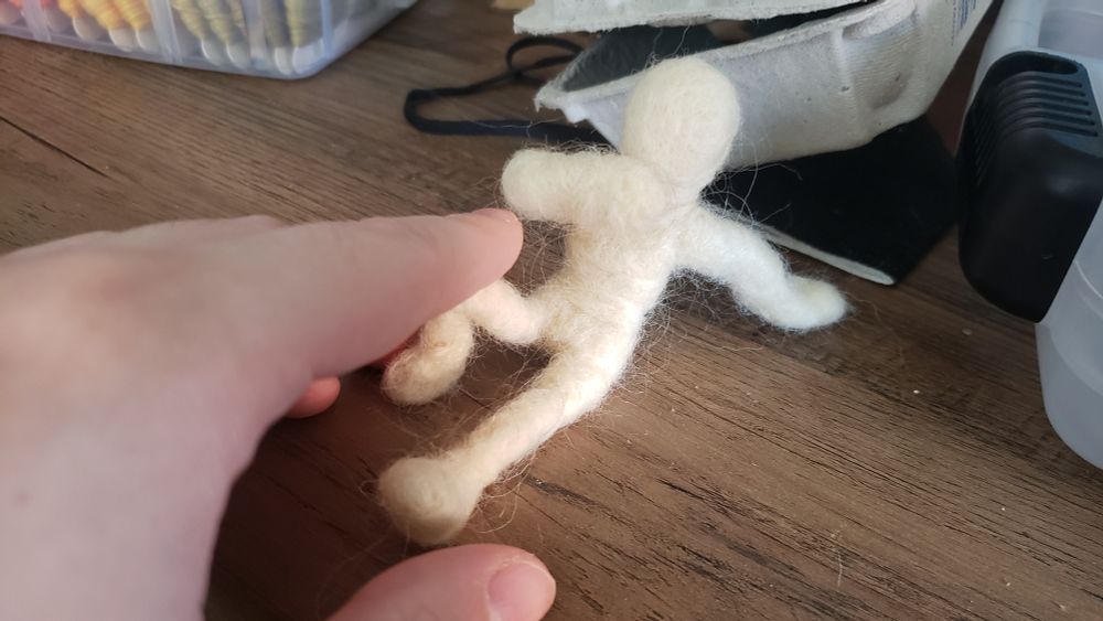 brin reaches towards an unfinished doll on her table. it shies away from her