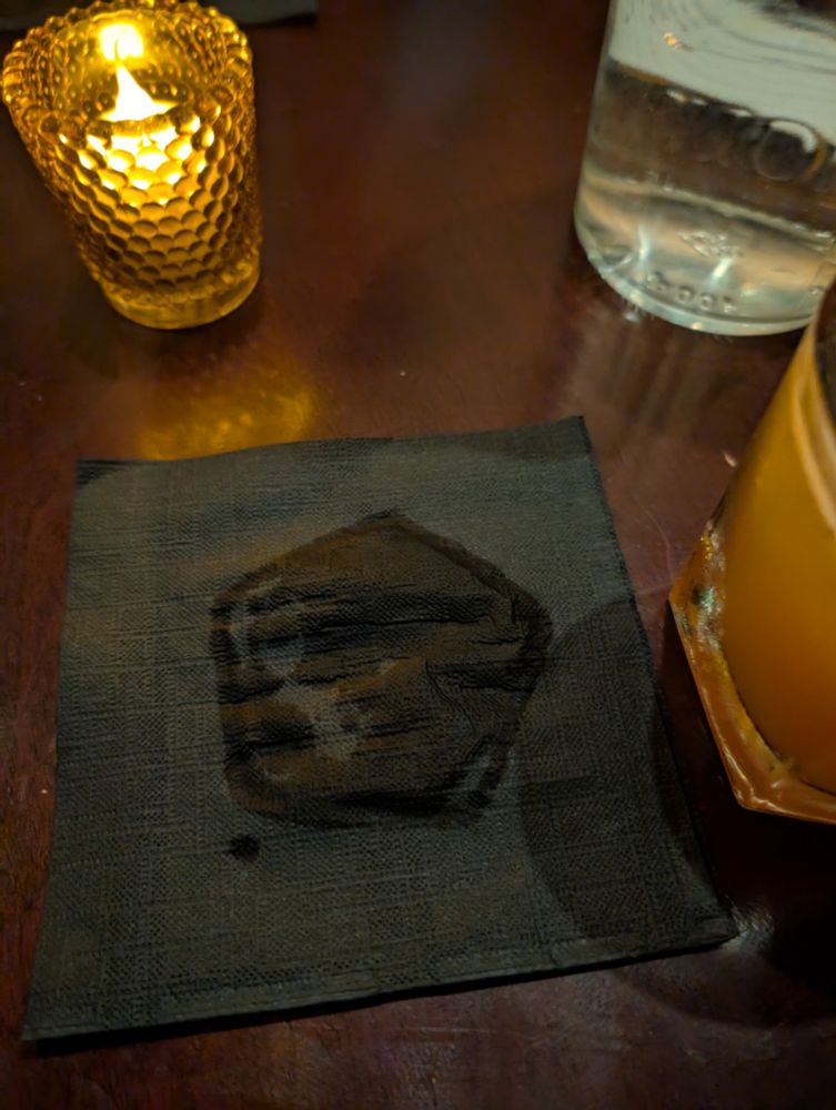 Photo of the pentagon shaped water mark left by a glass on a napkin.
