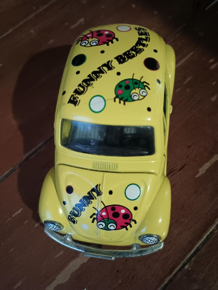 a toy Volkswagen beetle with beetles painted on it