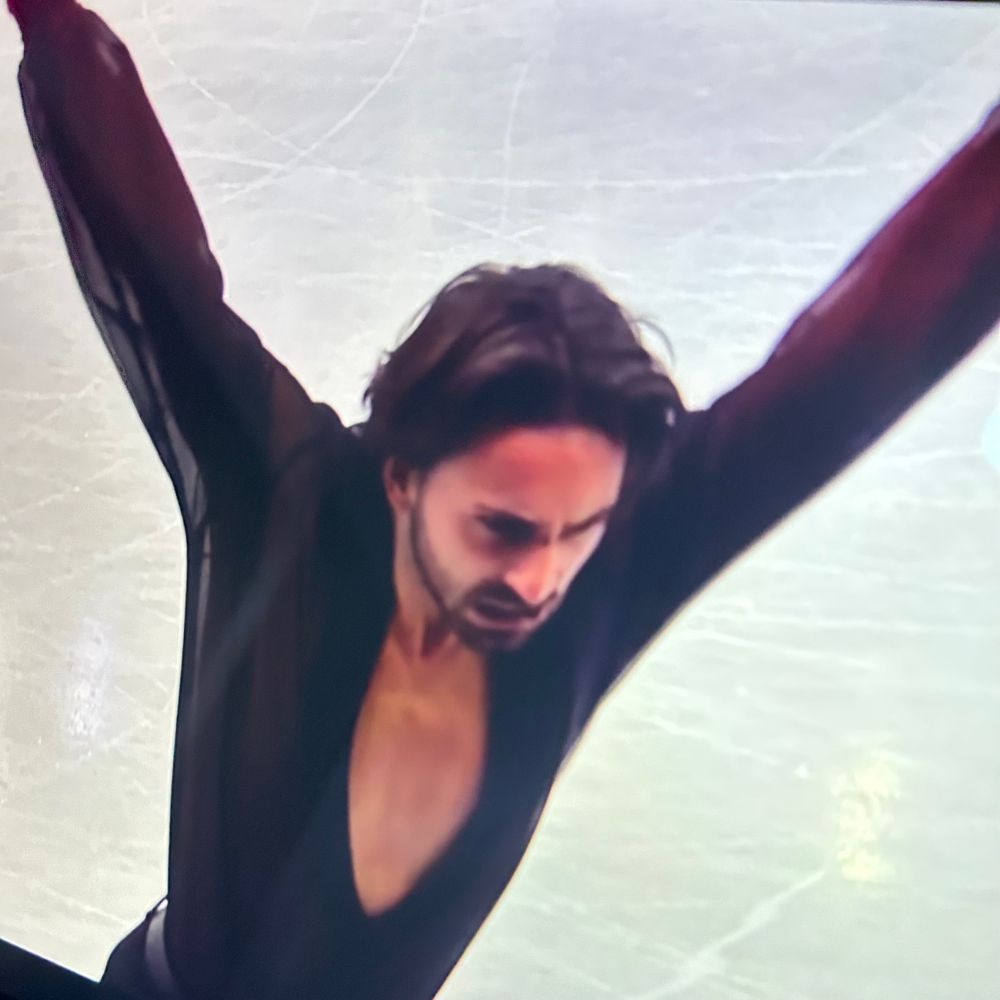 Kevin Aymoz, a French figure skater, at his ending pose for the free program where he dramatically stops right in front of the judging panel, raising both his arms up in a menacing way