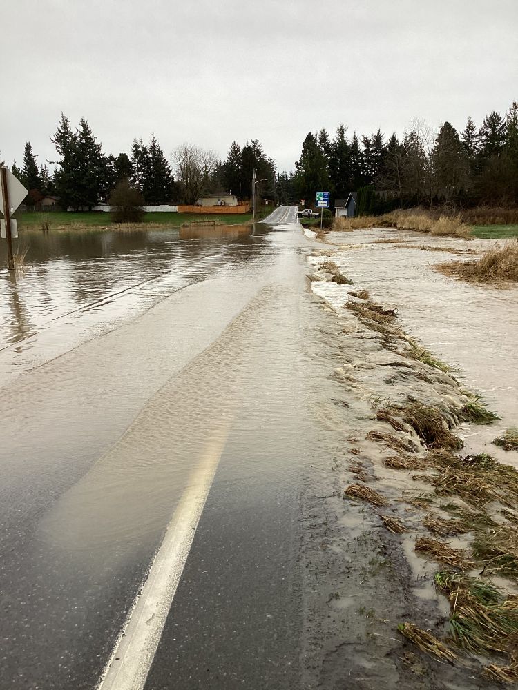 Image shows water spilling over State Route 9 in Everson.