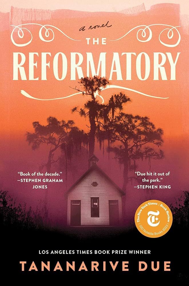 cover art of Tananarive Due's THE REFORMATORY: a shabby white school house in the middle of a sinister forest, cast in a peachy orange sunset. 