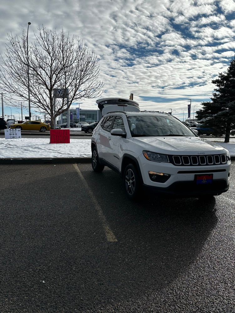 Photo of the parking lot view of my Pop Up. The red lawn sign reads “Sign Petition Here”