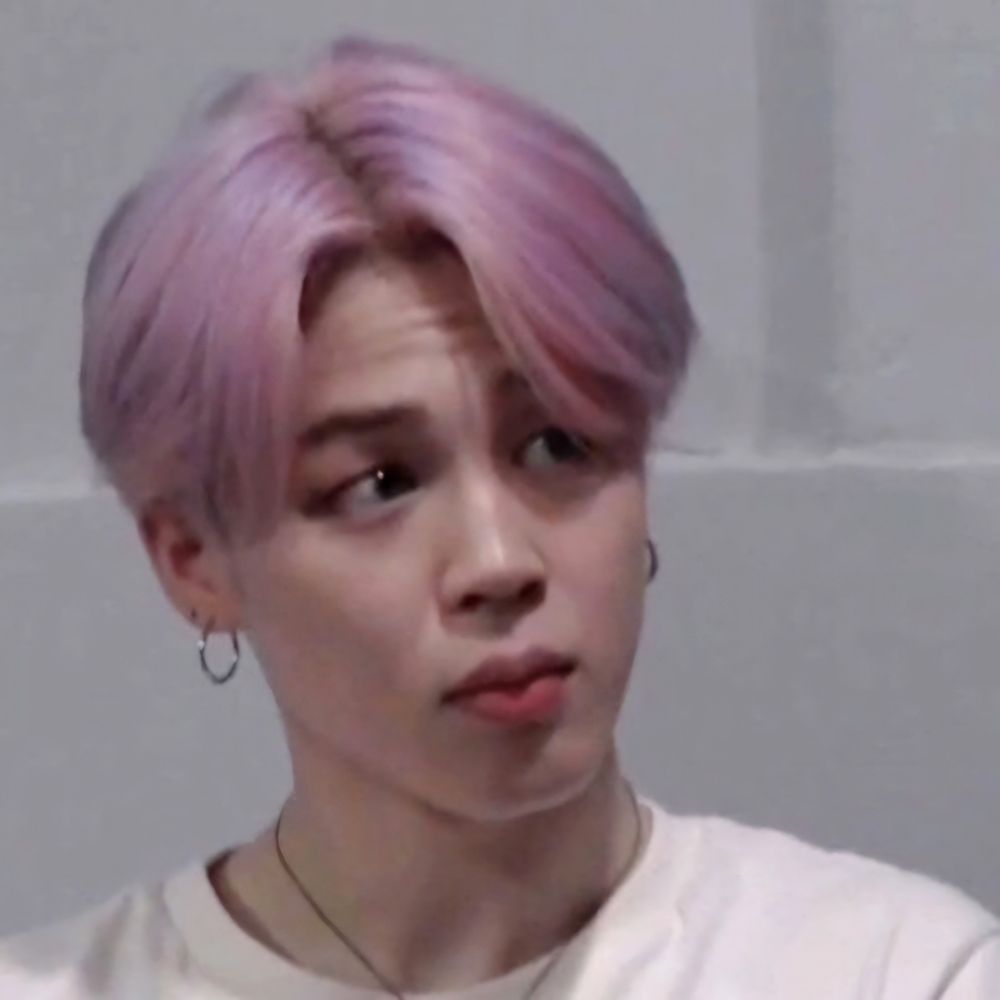 Jimin with pastel pink hair, wearing a white shirt