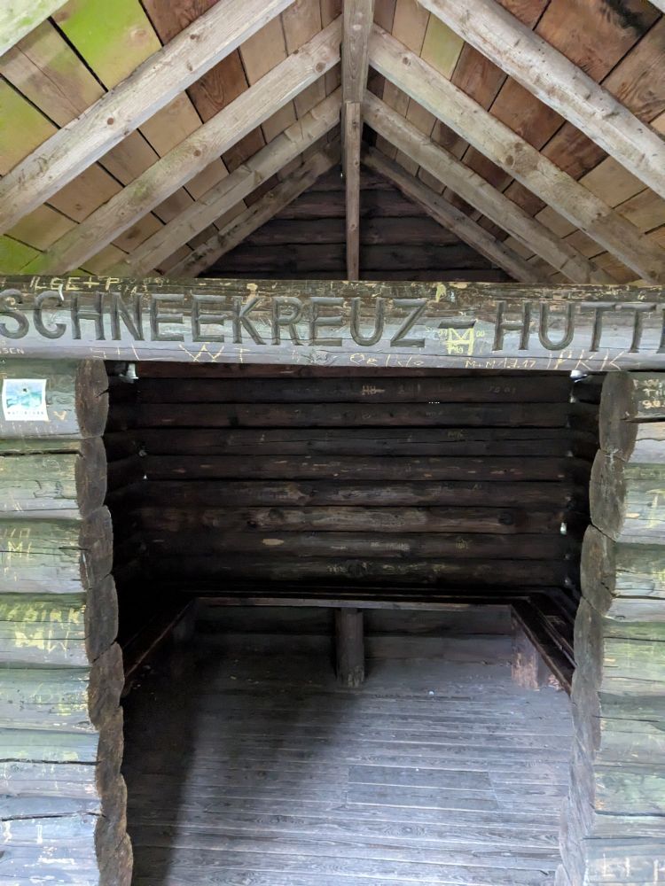 Holzhütte mit der in Holz geschnitzten Bezeichnung Schneekreuz-Hütte