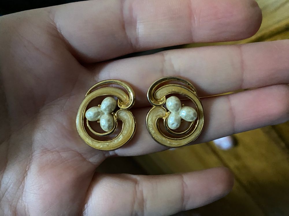 1980s “gold” costume earrings with three “pearls” in the centers and cream colored enamel swirls.