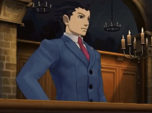 a man in a blue suit and red tie is standing in front of a chandelier