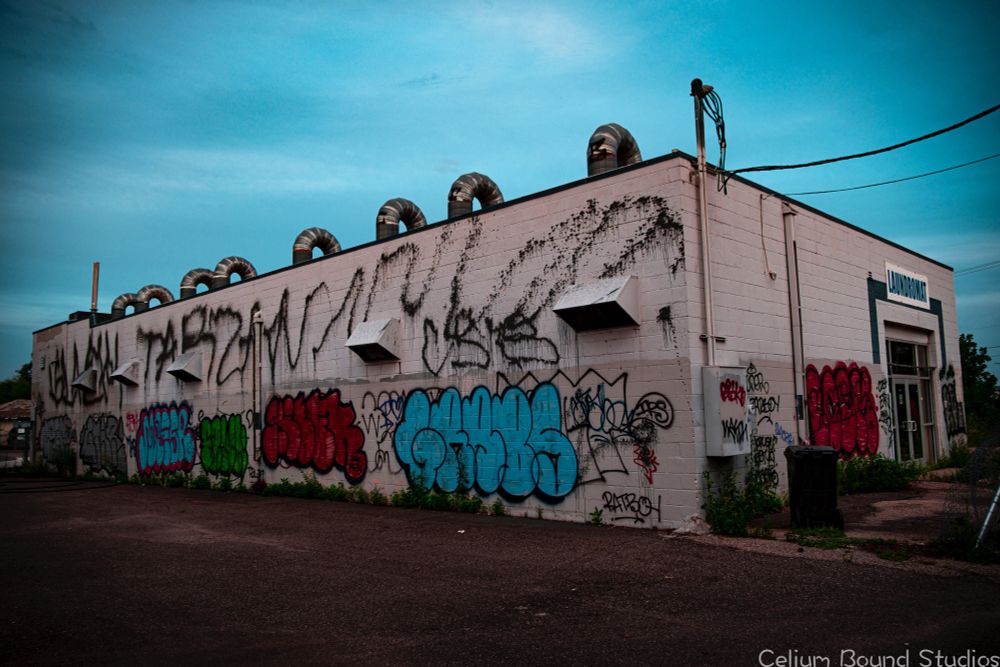 a stand alone laundromat covered in graffiti