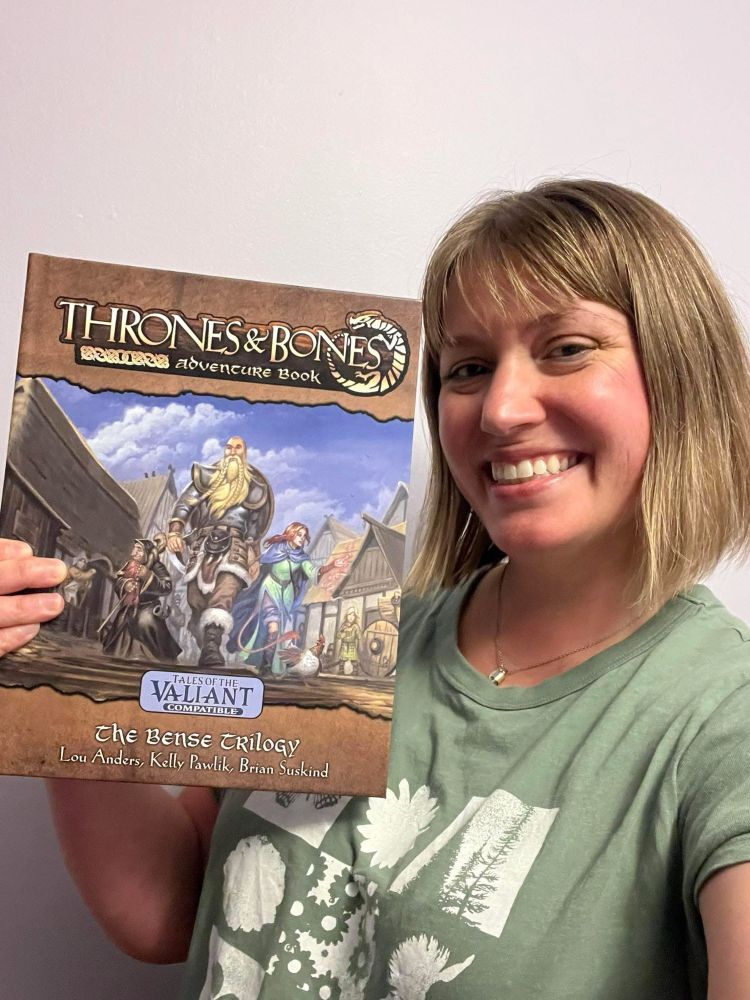 Kelly holding up a copy of the book. 