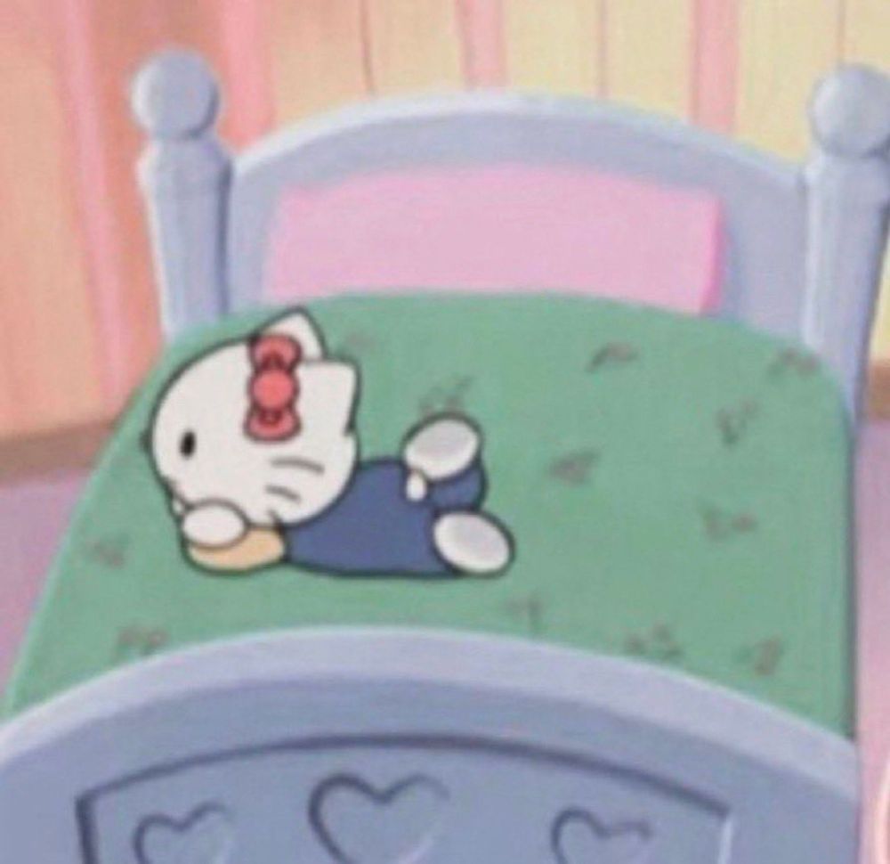 uma ilustração da Hello Kitti deitada de bruços com os braços segurando a cabeça. Ela usa um macacão azul e uma camisa de manga longa amarela. Ela está deitada em uma cama grande, da cor verde e ao fundo uma parede listrada amarelo e rosa.
