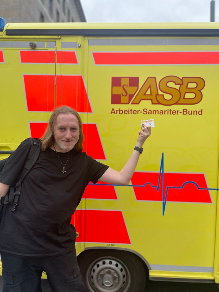 Ich mit meinem ASB-Mitgliedsausweis vor einem RTW des Arbeiter-Samariter-Bunds. 