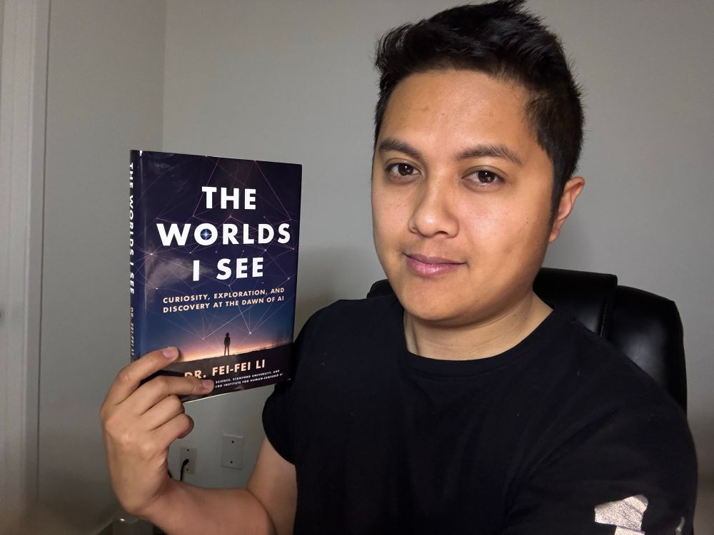 A picture of Kyle holding the book “The Worlds I See” by Fei-Fei Li.