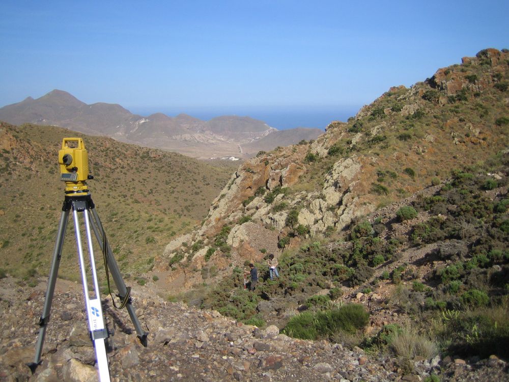 Heterogenous rocky habitat of Antirrhinum charidemi, with scientists establishing plant positions using a Topcon total station.