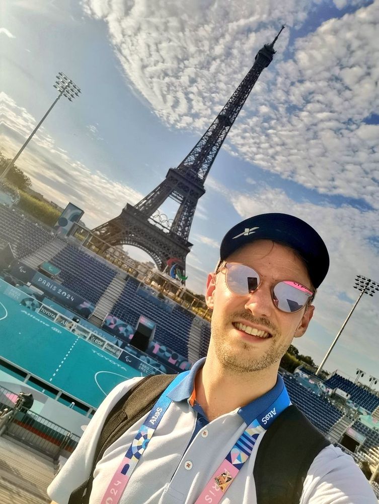 It's me, in Paris, in front of the Eiffel Tower and the Blind Football stadium below, during the Paris 2024 Paralympic Games.