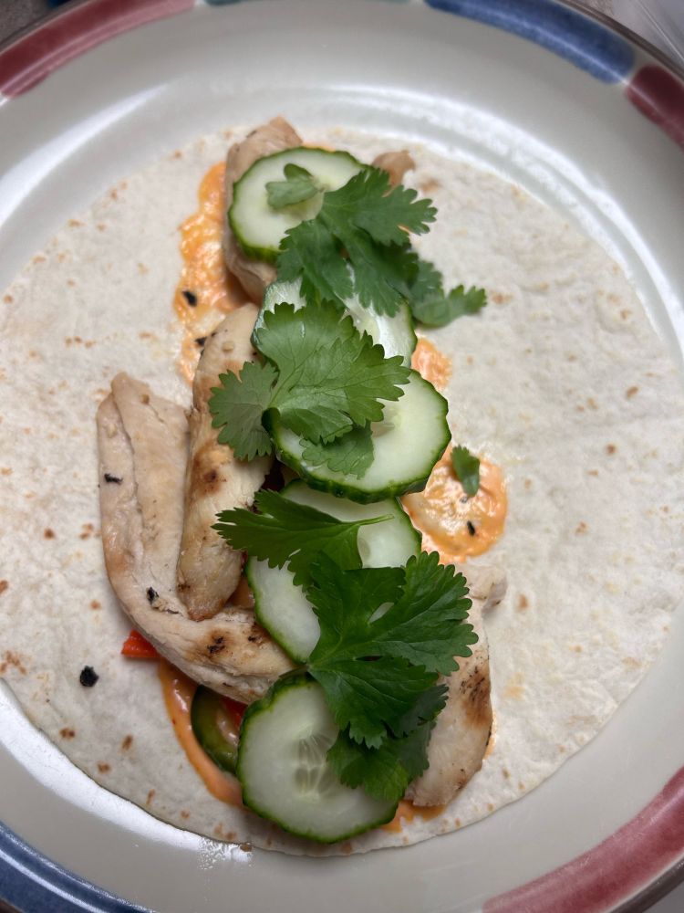 Tortilla filled with sriracha mayo, cilantro, cucumber, pickled carrots and jalapeños, and grilled chicken