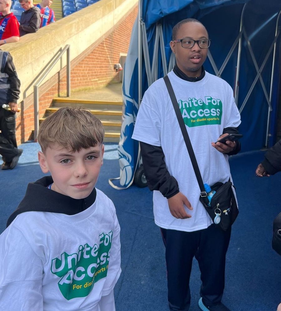 Two young DSA members in lpf unite for access t-shirts by the players tunnel before the match
