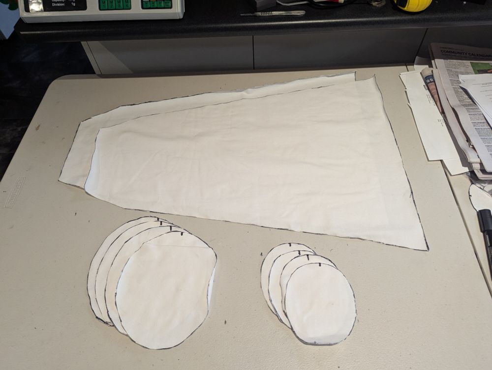 Pattern pieces of fabric cut out and laying on a table. 