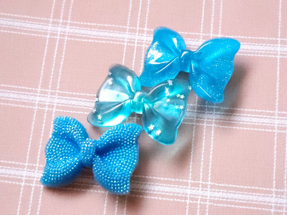 Dragon Dandy hairbowb shaped clippies in blue, one sparkly, one glittery, and one shimmery. 