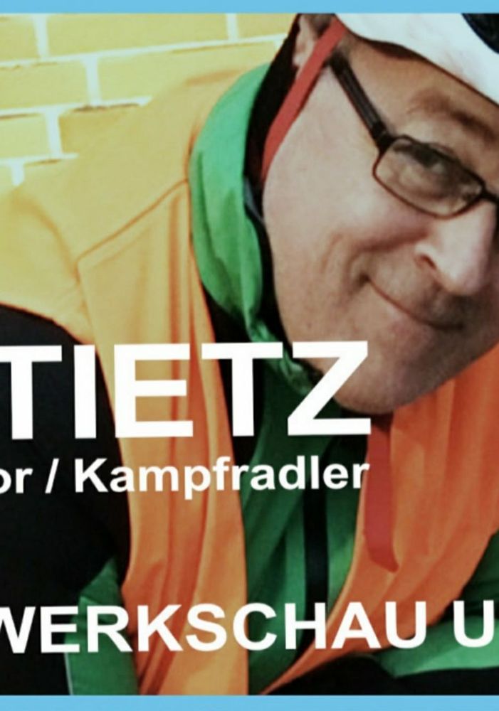 Ein alter Mann mit Brille, weißem Fahrradhelm und orangefarbener Warnweste über grüner Windjacke, lächelnd. Text im Bild: TIETZ, Kampfradler, Werkschau.