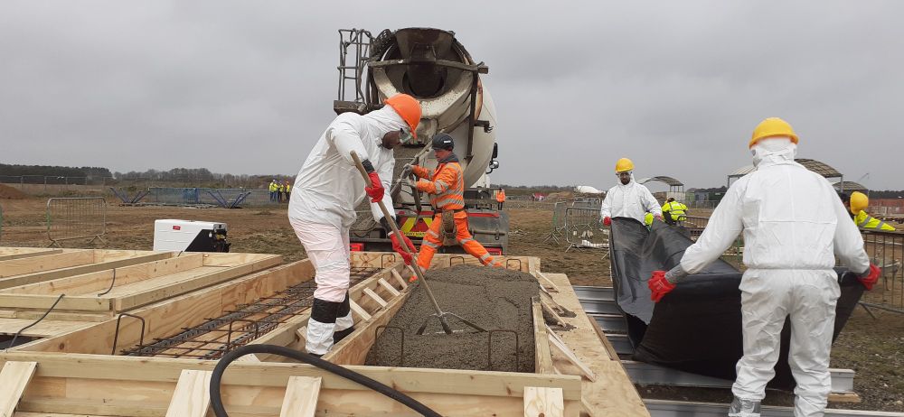 Spreading concrete within formwork for a precast station roof panel. 