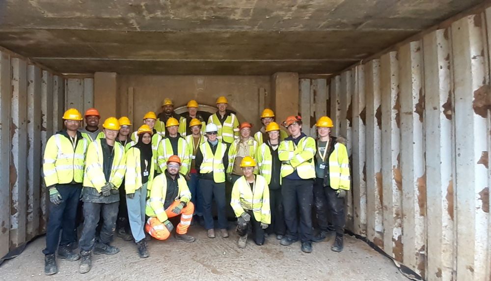 The student construction team inside North Greenwich stations, between sheet pile walls and beneath a concrete roof slab.