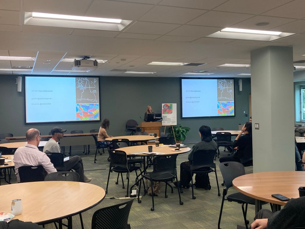 A photo of several scholars watching a presentation at the Global DH Symposium