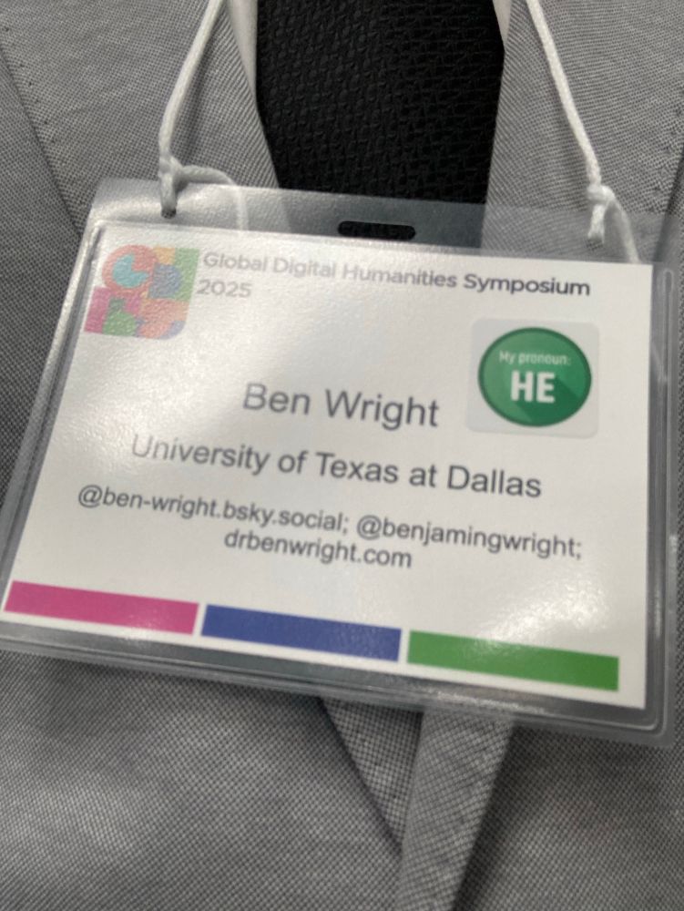 My name tag for the symposium which gives my name Ben Wright, institution the University of Texas at Dallas, my bluesky @ben-wright.bsky.social, twitter @benjamingwright, and website drbenwright.com